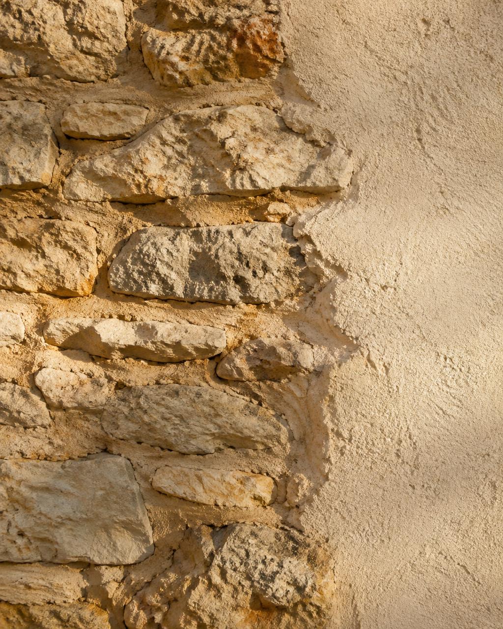 Détail d’un mur en pierre calcaire rejointoyé à côté d’un enduit à la chaux